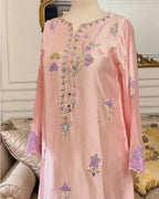 A light pink embroidered tunic dress displayed on a mannequin in an indoor setting. The tunic features purple and gold floral embroidery with scalloped cuffs.