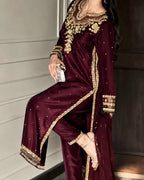 A woman models a deep maroon three-piece ethnic suit with intricate gold embroidery and silver mirror work, paired with a matching dupatta.