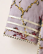Close-up of a lavender printed fabric sleeve with yellow and red floral branch motifs and three horizontal silver metallic bands near the cuff.